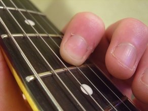 photo showing index finger fretting G string