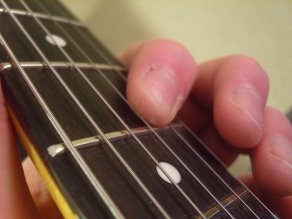 photo showing the index finger rolled back on to the B string