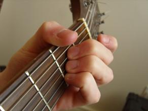 photo showing the thumb muting the low E string