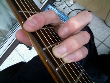 photo of E shape minor barre chord from guitarist's POV