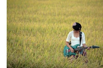 girl playing guitar in field