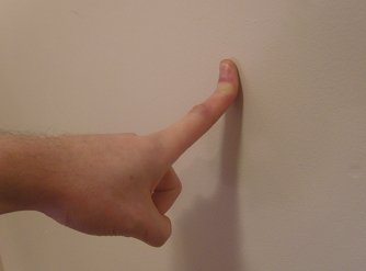 index finger stretched against a wall